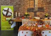 Ein Altar geschmückt mit herbstlichen Blättern und Früchten, links ein grünes Roll-up mit einem Brot und dem Schriftzug 5000 Brote - Konfis backen Brot für die Welt